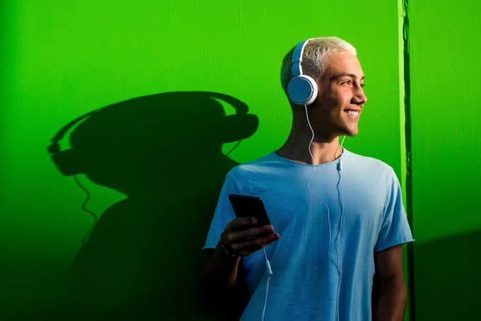 portrait of one teenager or young man listening to music using headphones millennial having fun hearing music