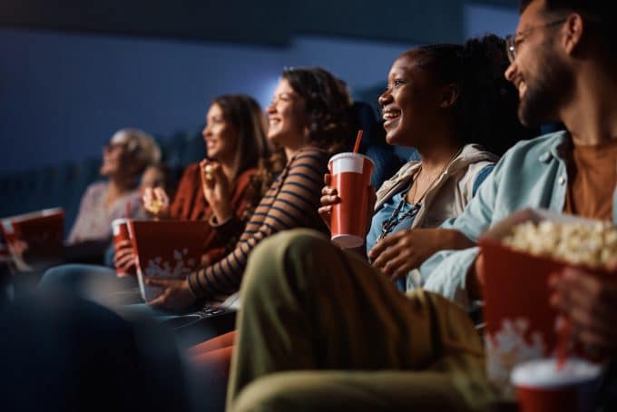 happy black woman enjoying in movie projection in cinema.